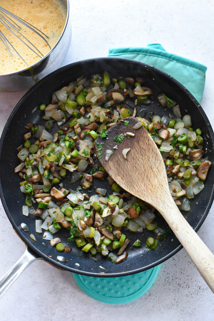 mushroom frittata recipe A nonstick pan with sauteed mushrooms, onions, and asparagus.