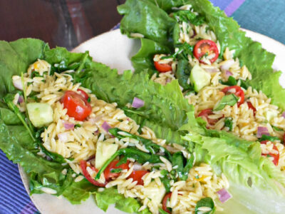 Orzo pasta salad lettuce wraps on a white plate.