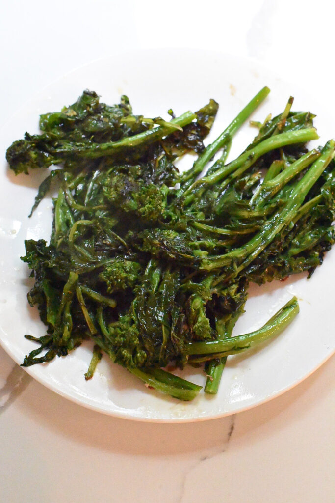 A plate filled with cooked broccoli rabe.