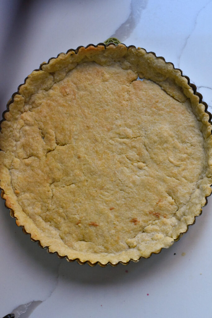 A finished cooked tart crust on a white counter.