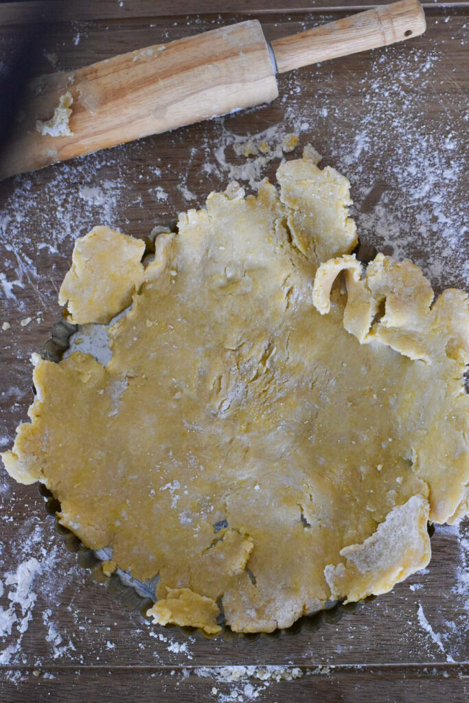 Tart dough pressed into a tart pan with a removable bottom.