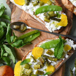 A few pieces of burrata toast with asparagus, snap peas and garlic confit.